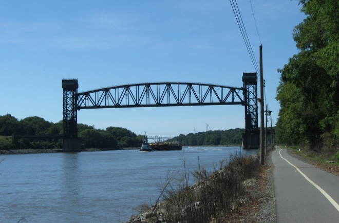 Tugboat and barge approaching the railroad bridge